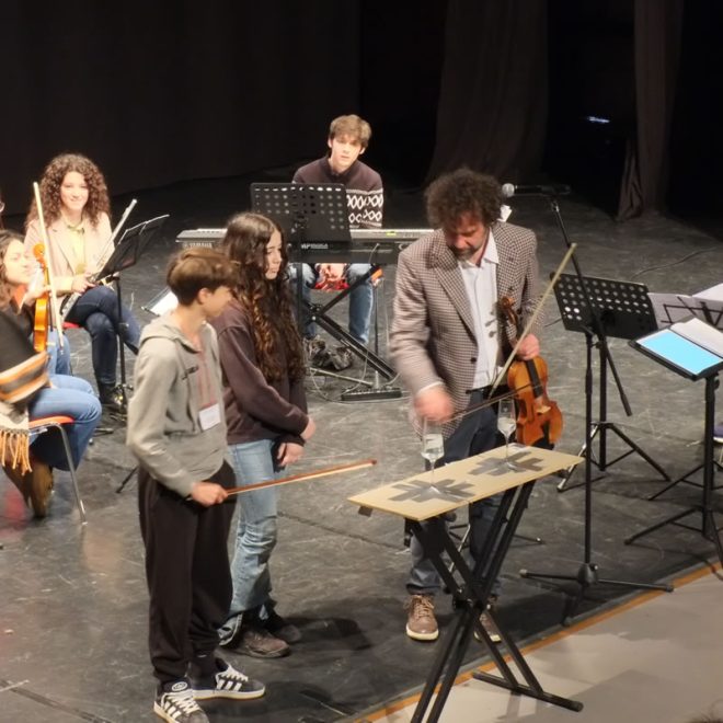 Musicisti e studenti sul palco durante una lezione-concerto