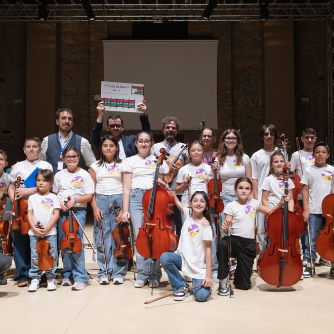 Foto di gruppo dell'orchestra di bambini e ragazzi con violini e violoncelli