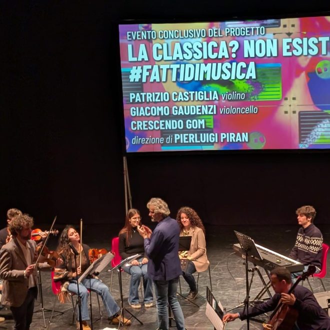 Ensemble di archi in concerto sotto lo schermo con il titolo La classica? Non esiste!