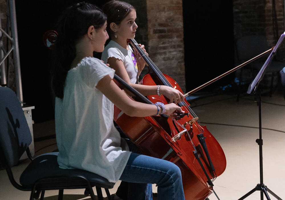 Due ragazze suonano il violoncello durante un concerto