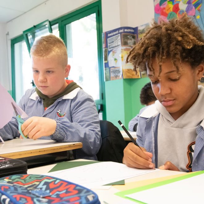 Ragazzi lavorano a un'attività creativa sui banchi di scuola
