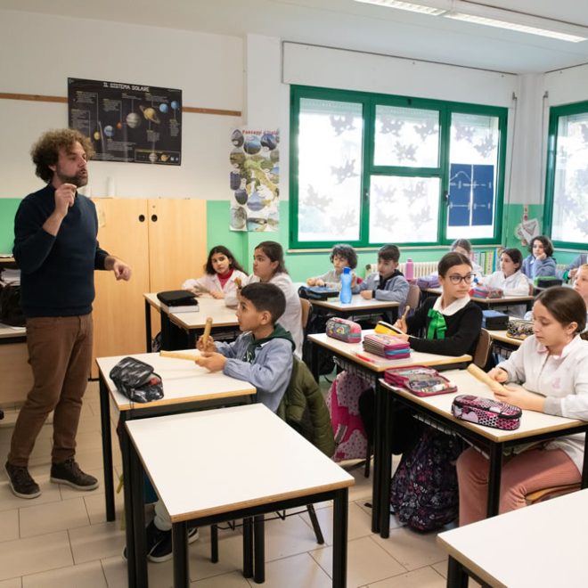 Musicisti ed educatori conducono un laboratorio in un'aula scolastica